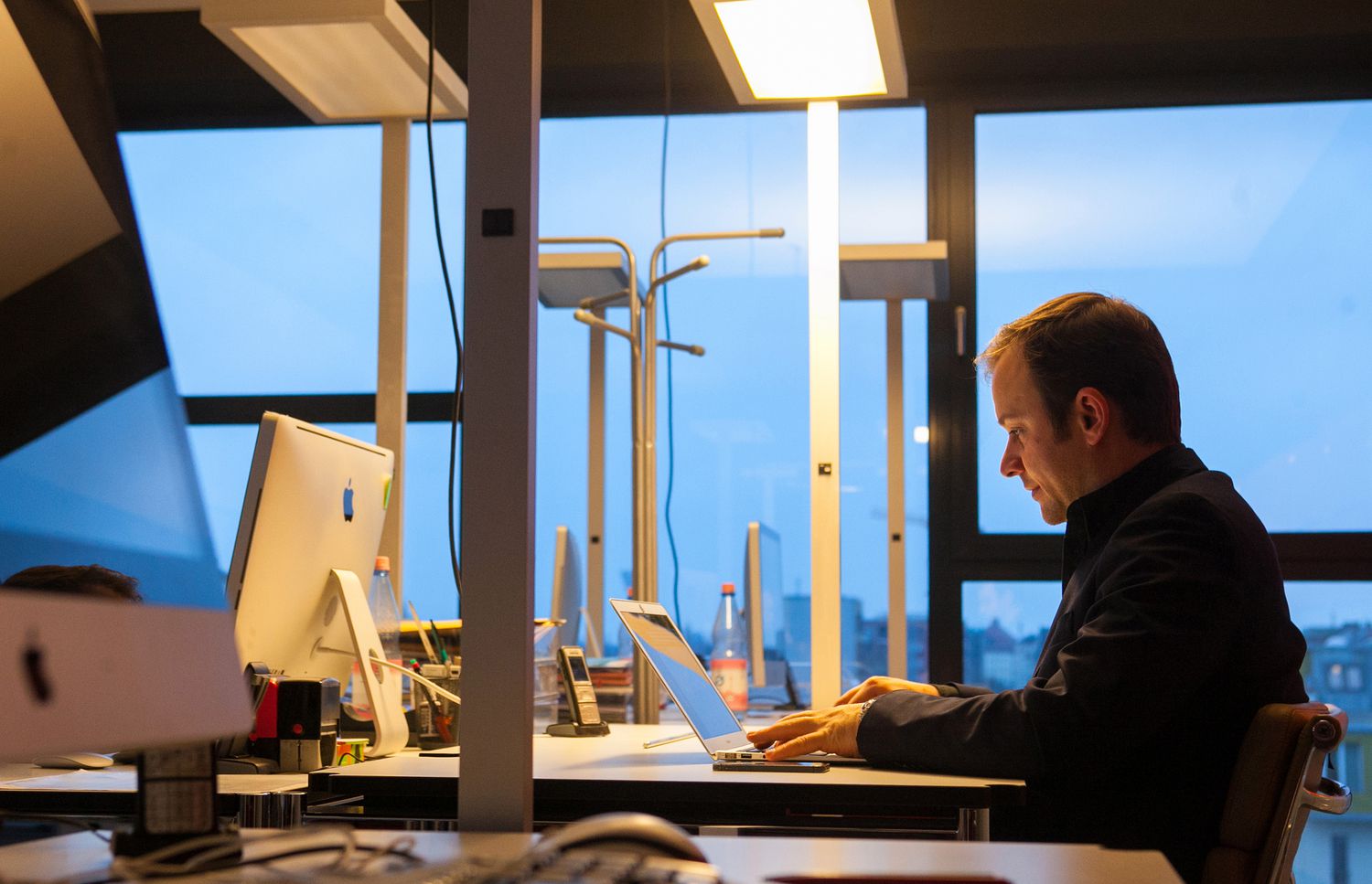Man sitting in an office working on a laptop