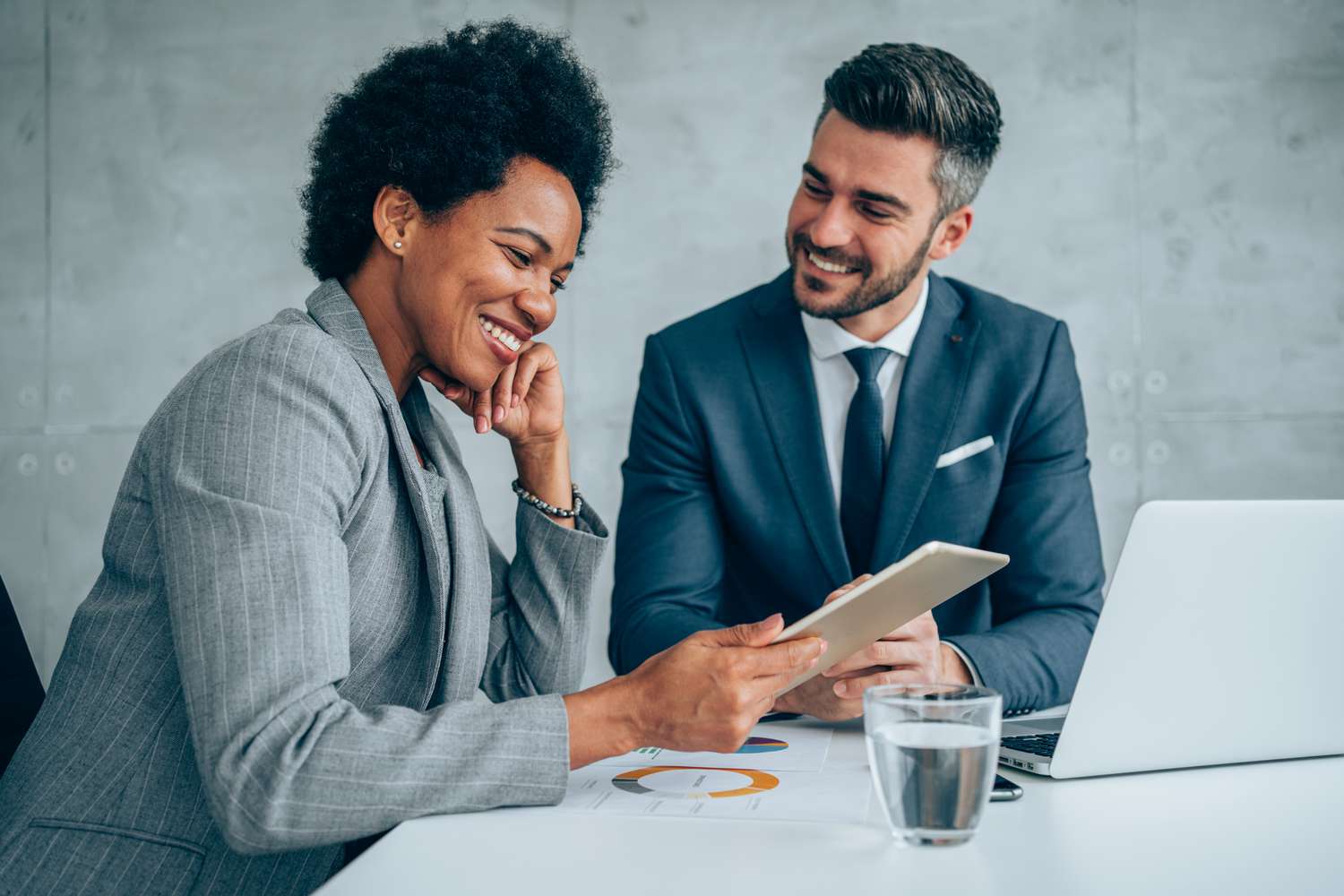 Work colleagues smiling next to a computer