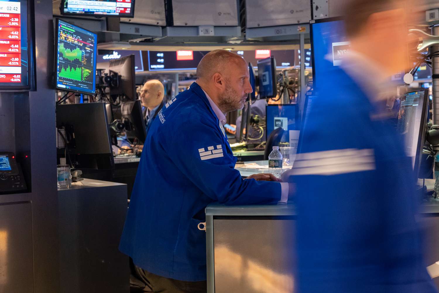 People walk on the floor of the New York Stock Exchange