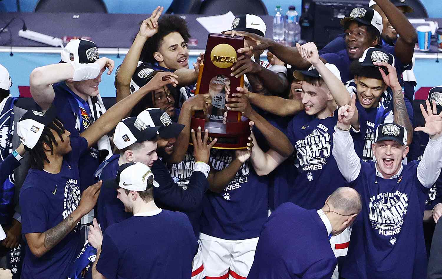 The University of Connecticut Huskies celebrate with the NCAA tournament trophy after winning the 2024 championship.