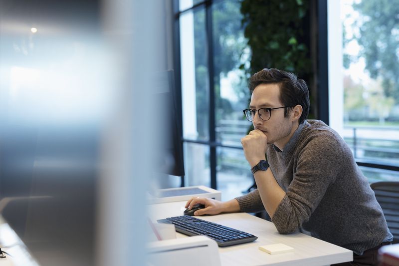 Businessman working at computer in office.