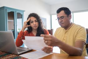 Worried looking couple looking at bills.