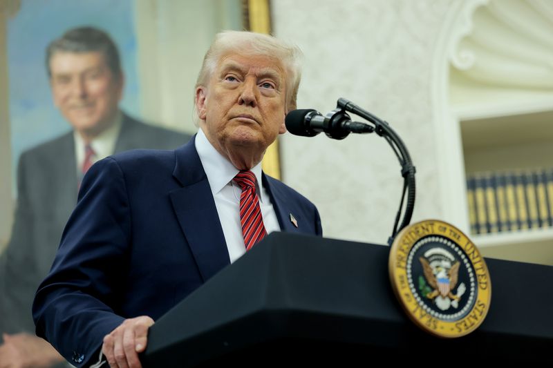 Donald Trump stands in front of a podium with the presidential seal on it. 