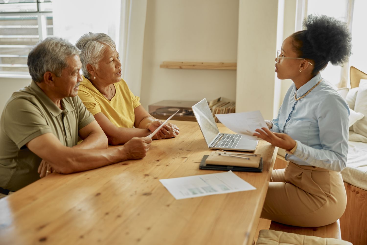 Senior couple exchanging information about the maximum amount they can receive from a reverse mortgage with their financial advisor.