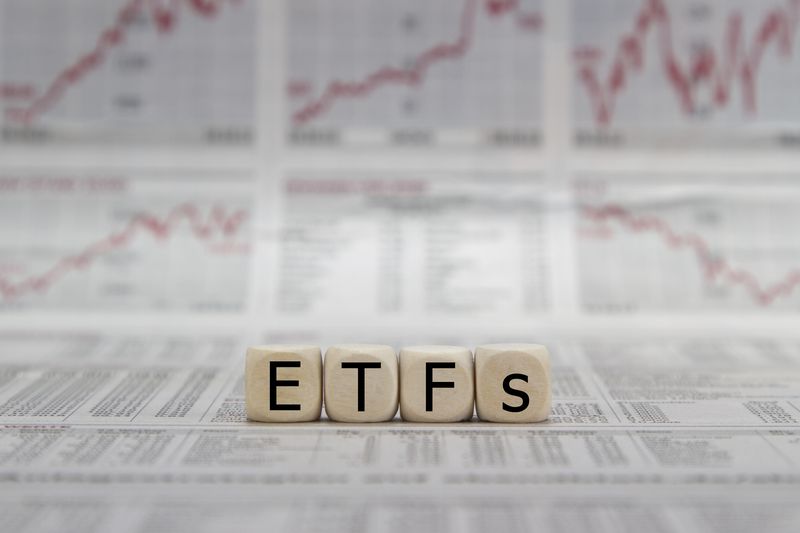 ETF exchange trades funds word on a blurred business newspaper.