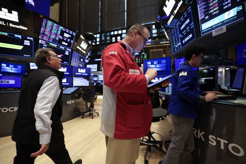 Traders looks at a tablet on the floor of the New York Stock Exchange