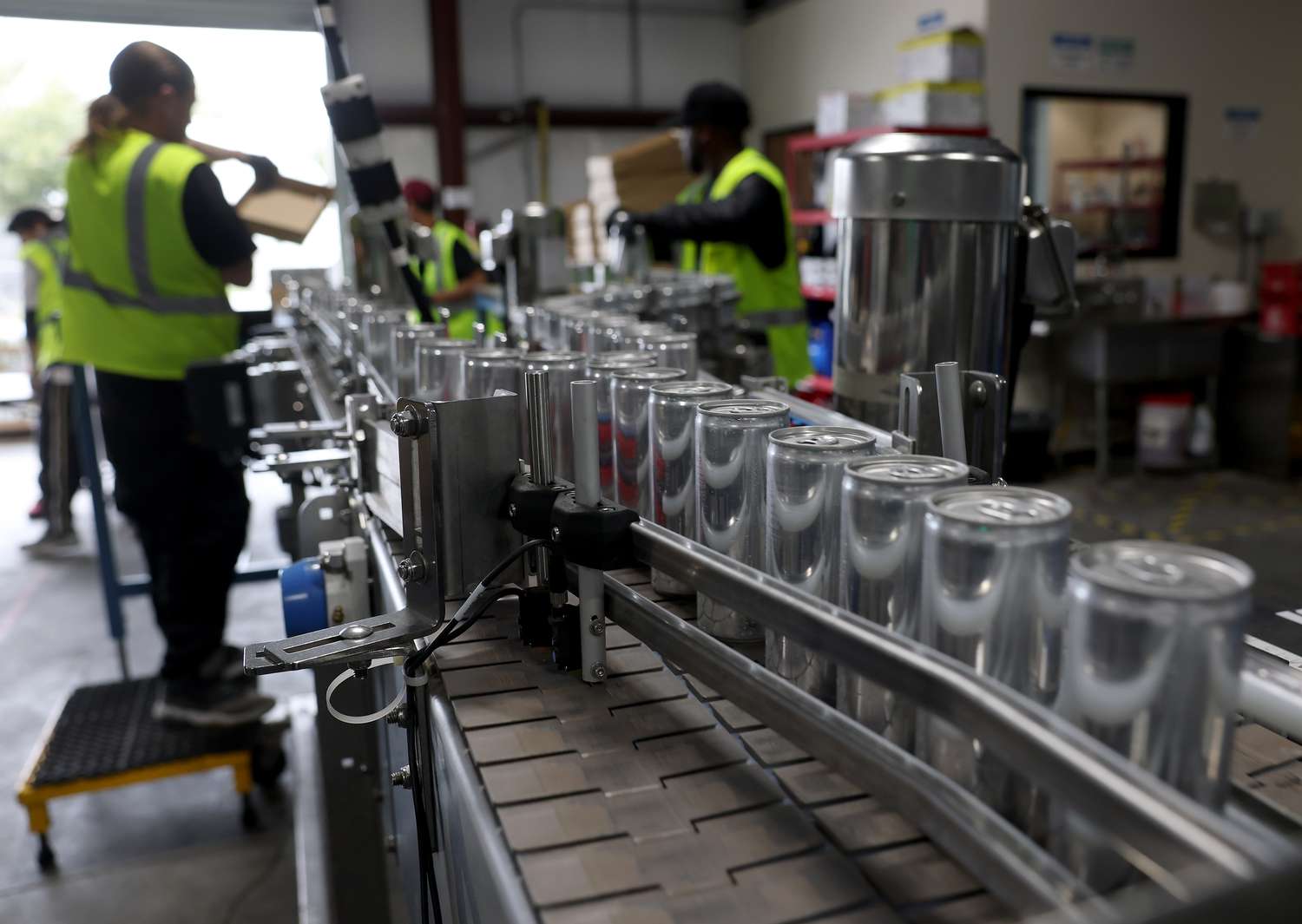 Cans of freshly canned beer move on an assembly line at The Can Van headquarters on February 19, 2025 in Sacramento, California.