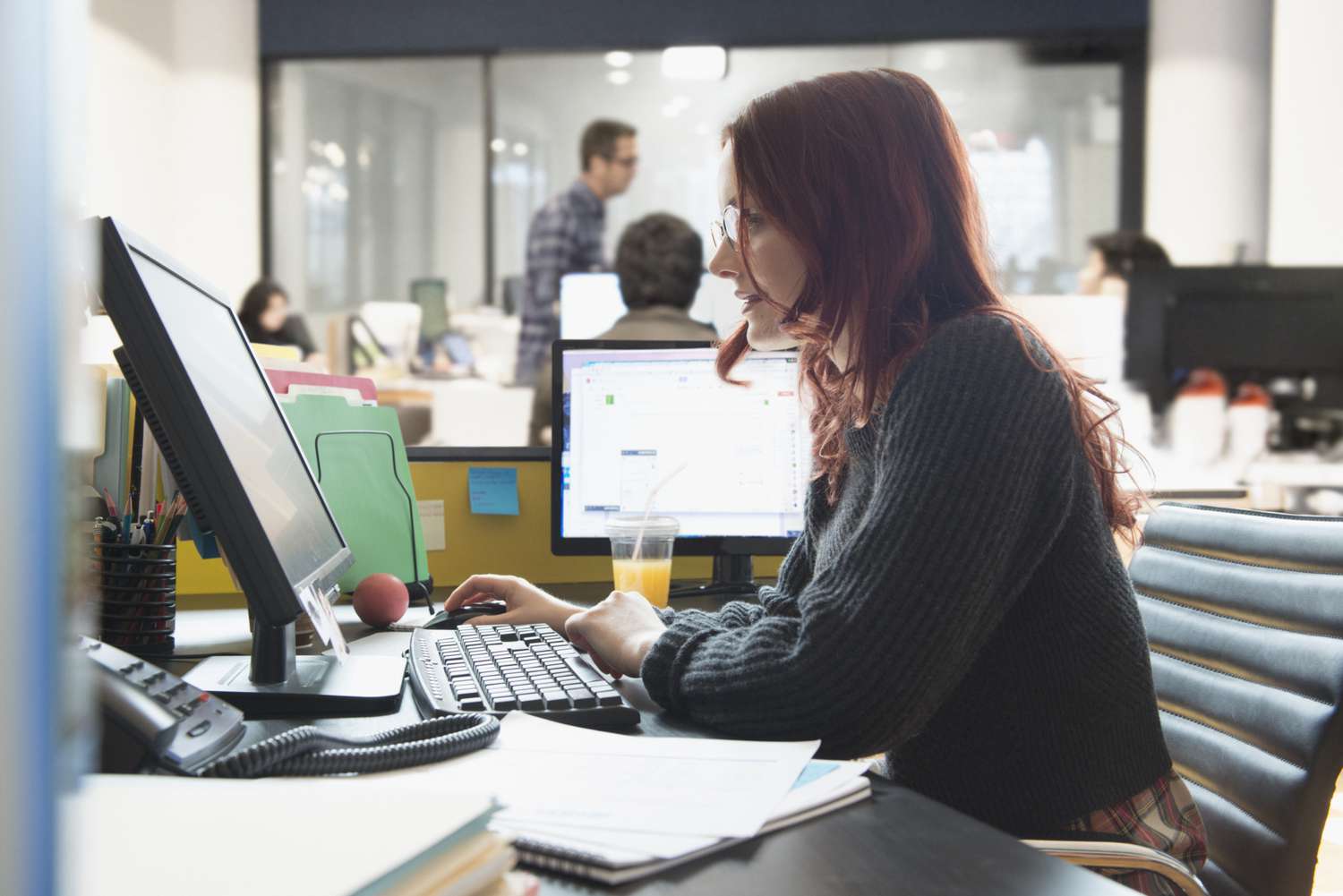 Bank employee using Mortgage Electronic Registration System (MERS) on the PC in the office to track mortgage transfers.