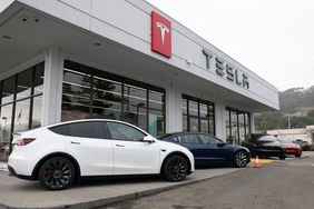 Four Tesla vehicles are seen outside the building of a Tesla dealership.