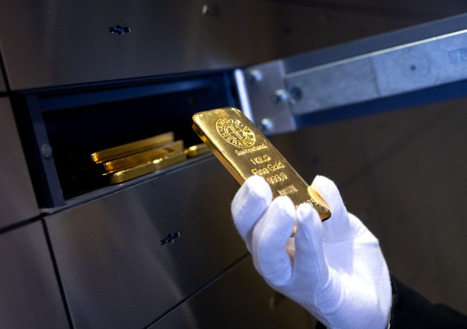 A man places a gold bar in a safe deposit box.