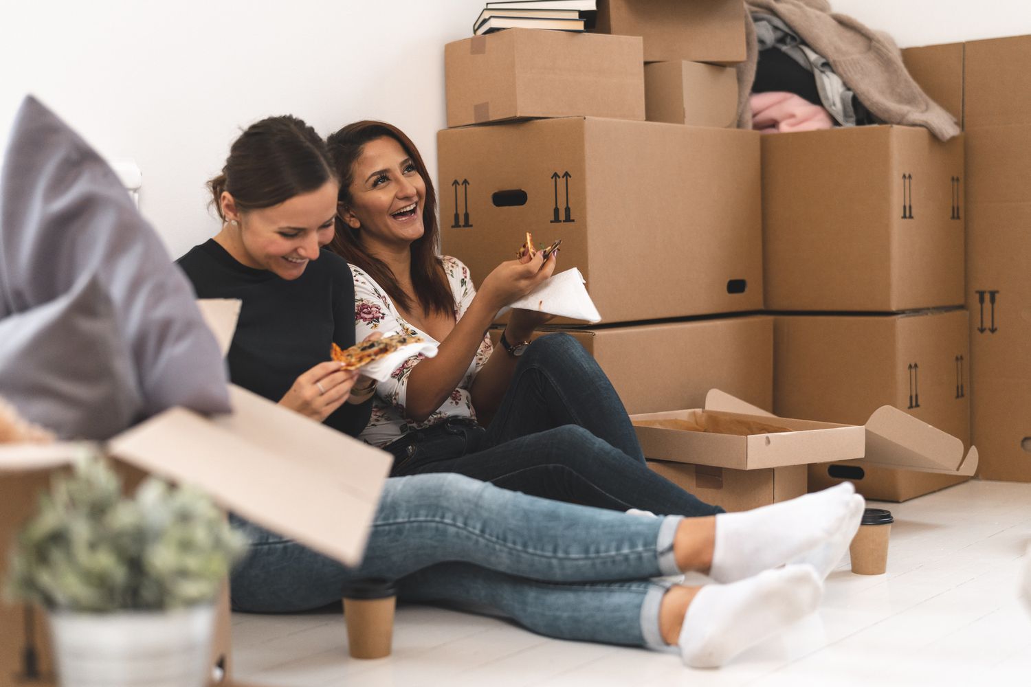 Best friends eating pizza while moving home