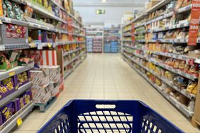 A stock image of a cart in a grocery store aisle. 