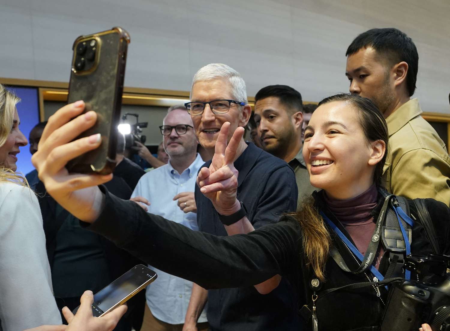 Apple CEO Tim Cook poses with customers during Apple's iPhone 16 launch in New York on Sept. 20, 2024