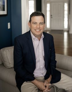 Jay Hummel sitting on an armchair in an entryway