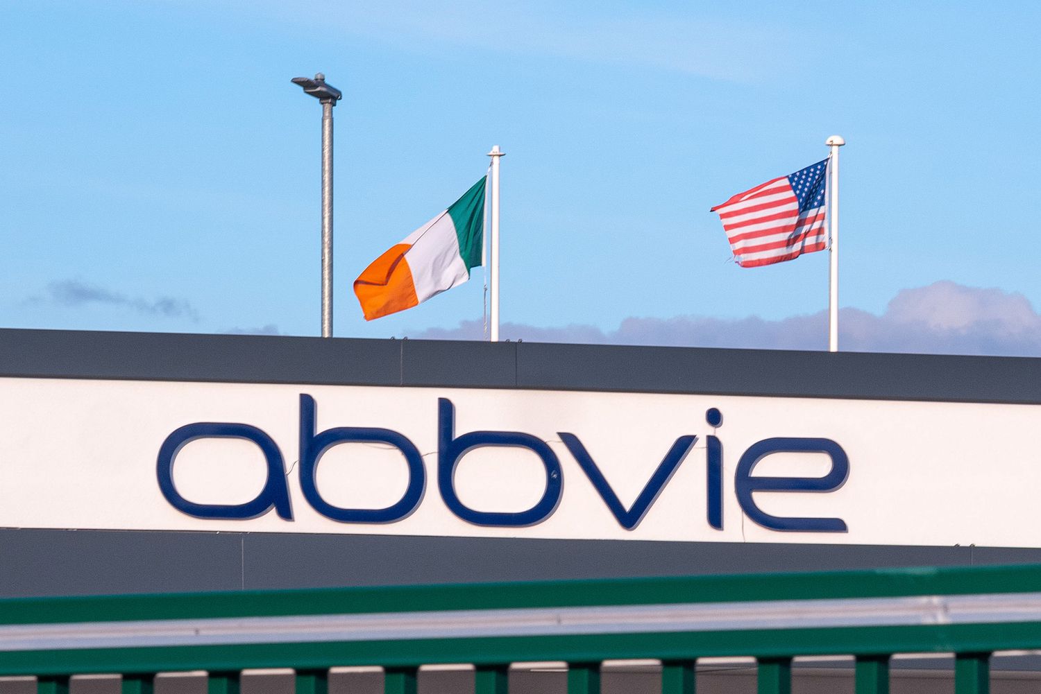 The AbbVie logo is seen on the side of a building, with the American and Irish flags in the background.