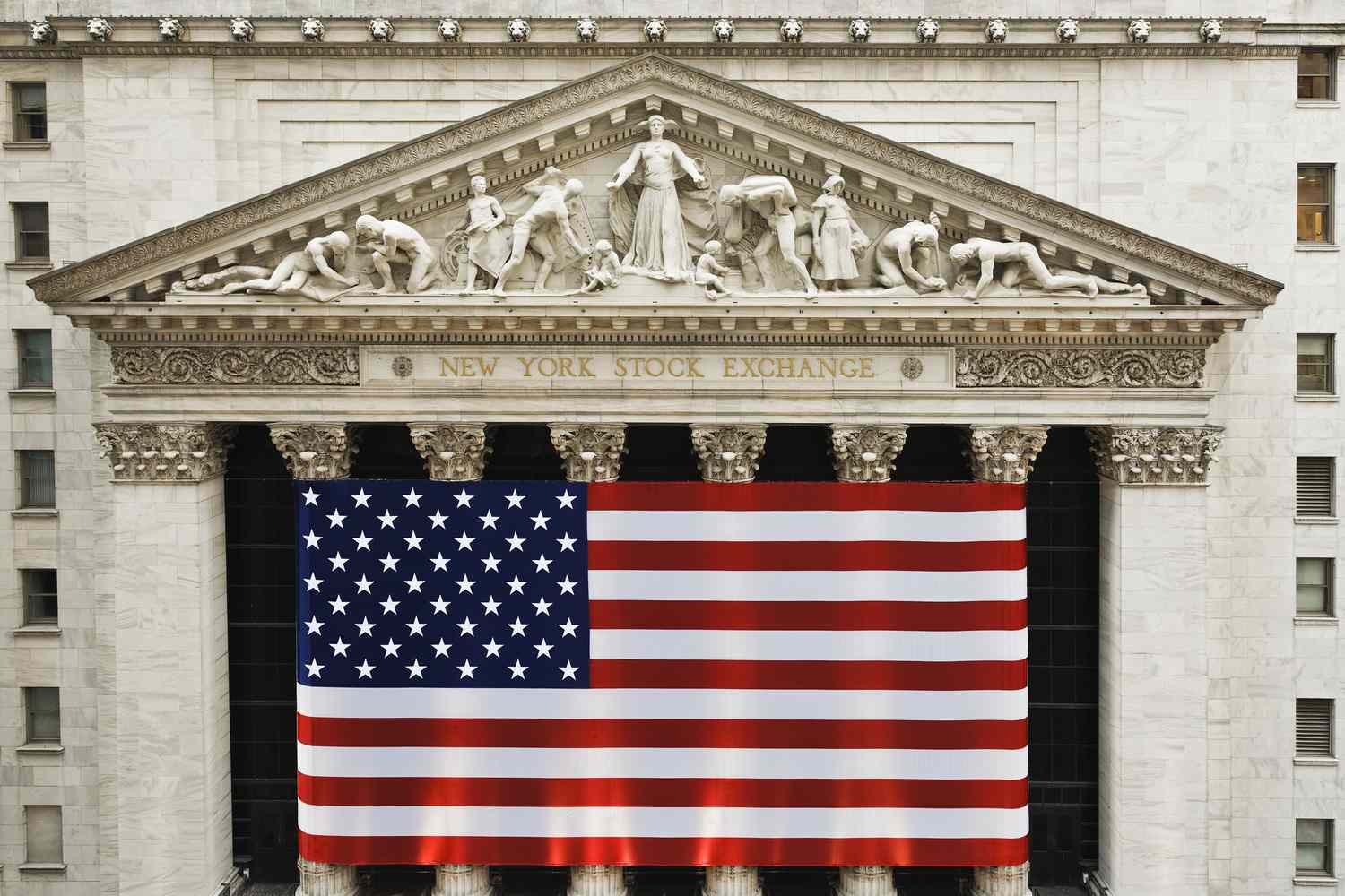 An American flag covers the front of the New York Stock Exchange building.