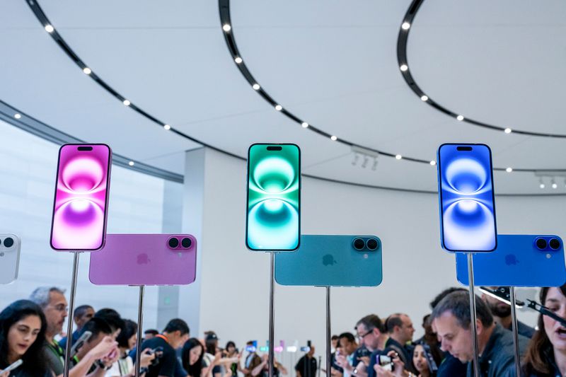 Blue, pink, and green versions of the iPhone 16 is displayed at an event at Apple's California headquarters.