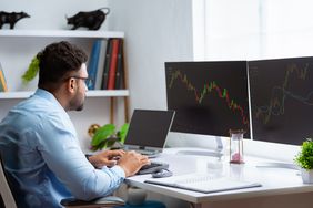 Portfolio manager at desk with market charts implementing tactical asset allocation.