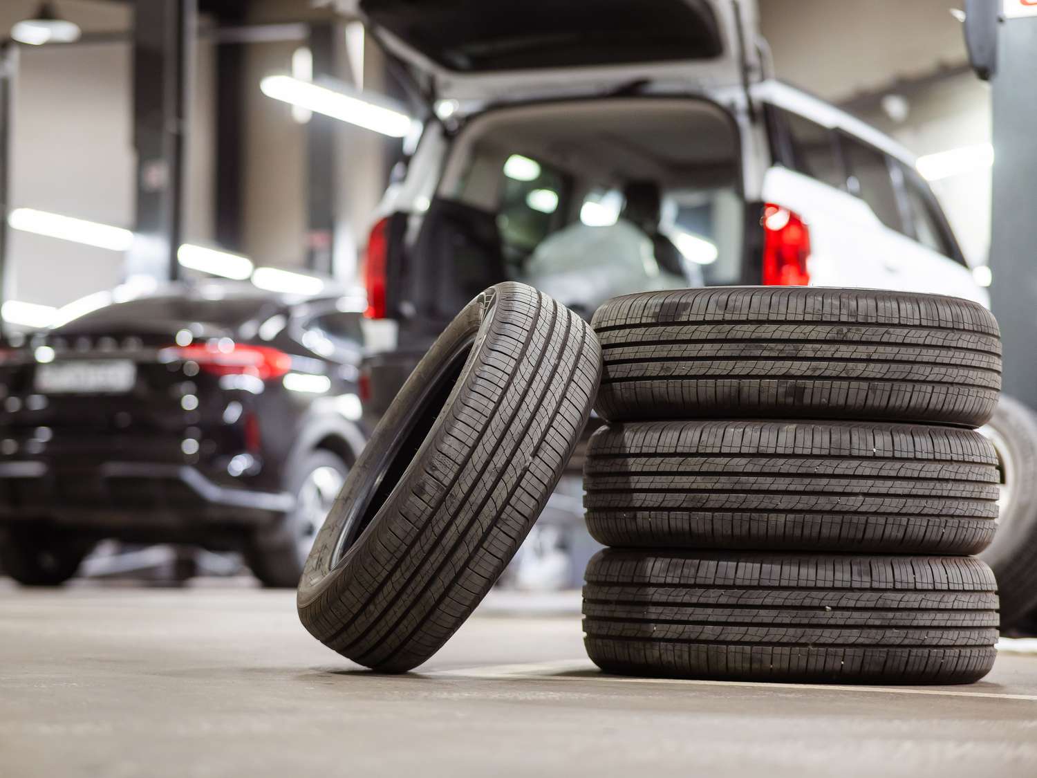 Stack of tires in front of cars.