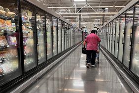 A customer walks down an aisle at Walmart. 
