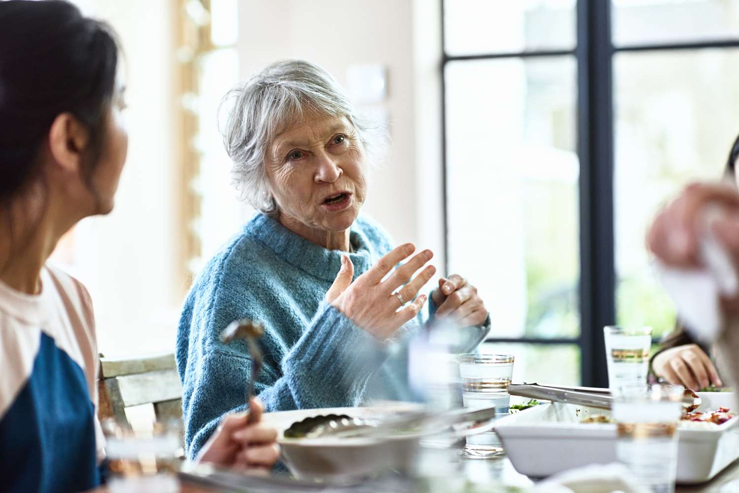 A woman is talking to others at a table.