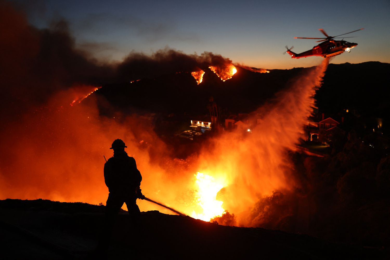 Firefighters battle flames in Pacific Palisades, Calif., on Tuesday.