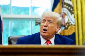 President Donald Trump sits behind a desk, with flags donning the presidential seal behind him. 