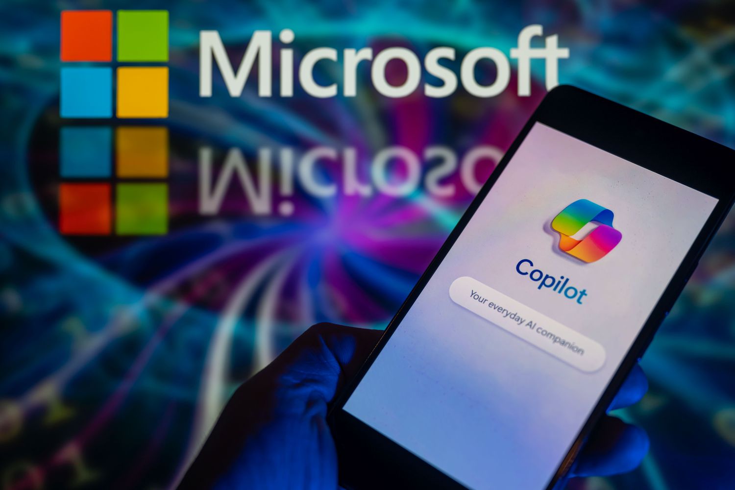 Microsoft Copilot app on a smartphone screen with Microsoft logo in the background