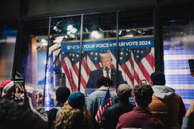 Onlookers watch a broadcast of former US President Donald Trump addressing his election night watch party.