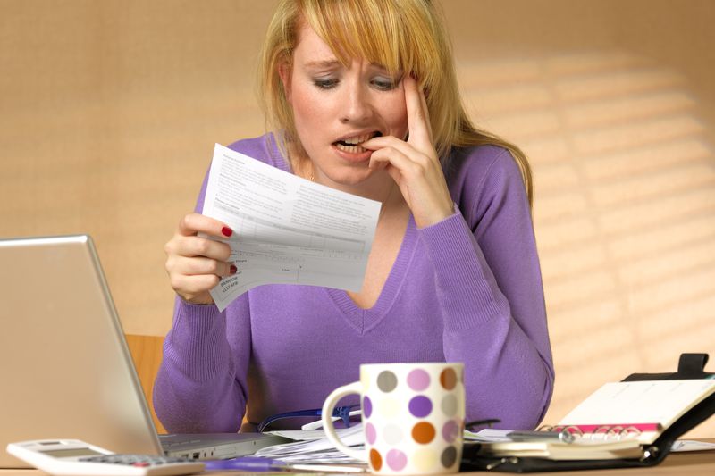A person at a desk looks flummoxed looking at a tax bill.