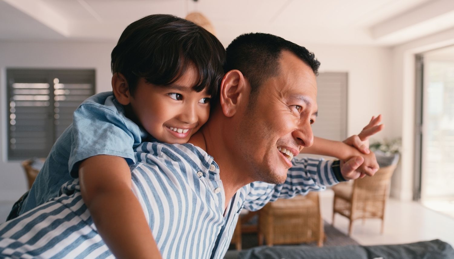 Flying, child and dad with piggyback for playing in home with bonding, fun game and support with smile. Family, man and boy kid on shoulder for airplane fantasy with imagination, trust and freedom