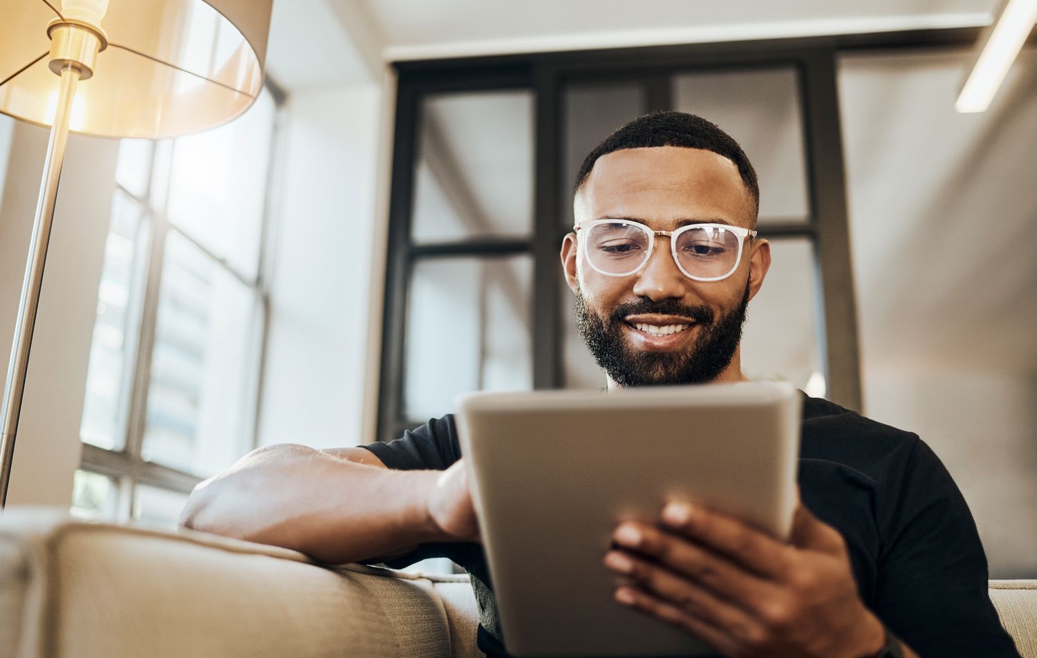 A man looks at his tablet and smiles 
