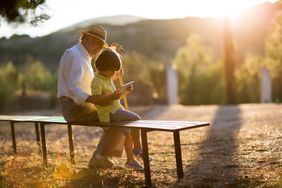 A grandfather and grandson sitting on a bench