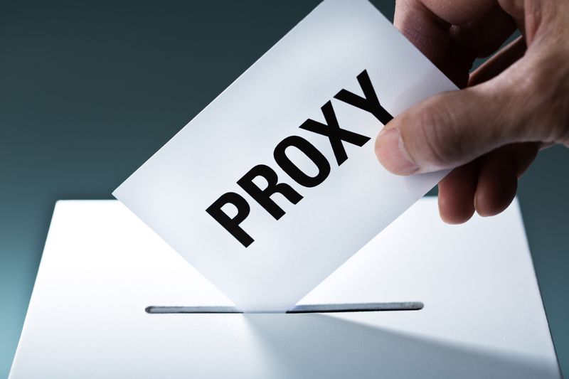A man placing a proxy ballot in a box