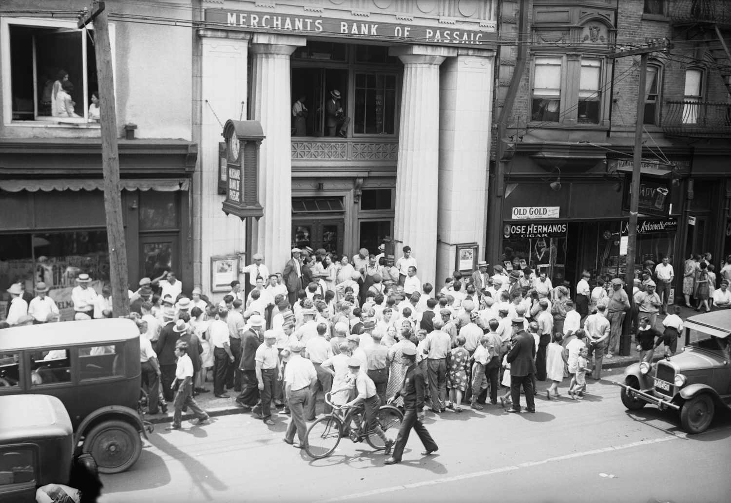 A crowd of people gather in front of a bank during the market crash of 1929.