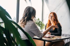A new employee sits in an office and listens as the human resource manager explain the difference between a Roth IRA and a Traditional IRA.