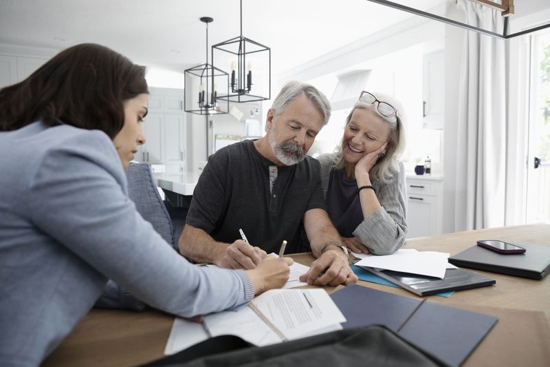 Couple talking with a financial advisor about funding their living trust.