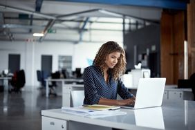 A woman works at a laptop.