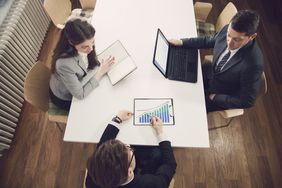 A group of financial experts analyzing financial statistics, having a conversation at the office and making suggestions on improving their business project.