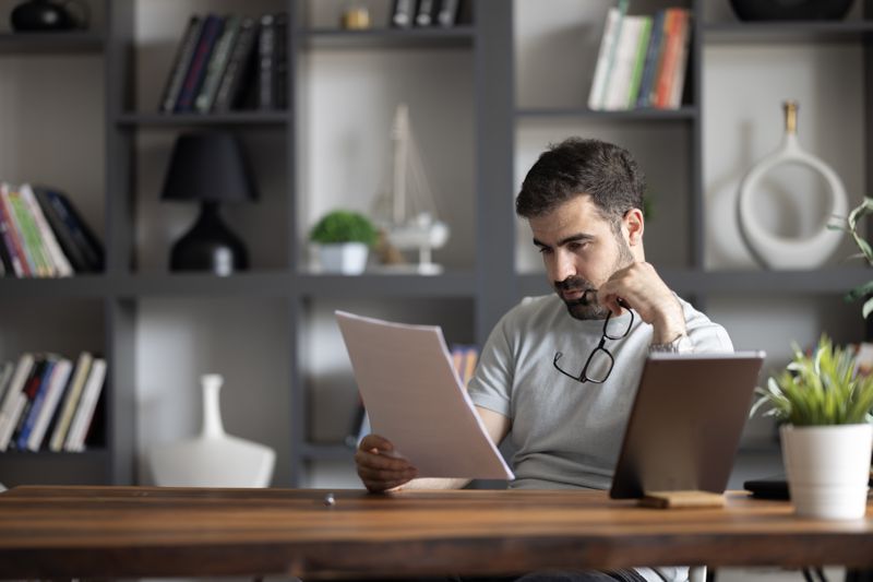 A man reviews paperwork at a desk.
