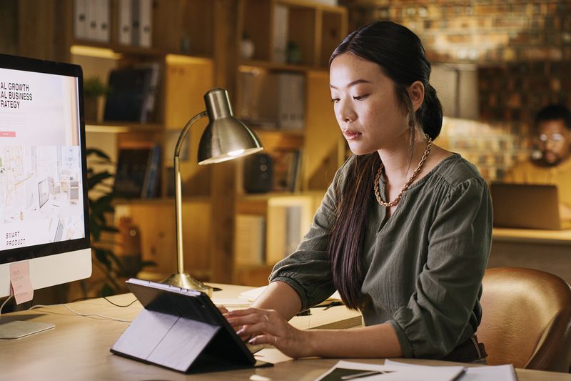 A website designer uses a tablet to comfirm the page desgin they just completed works on both PC and tablet devices.
