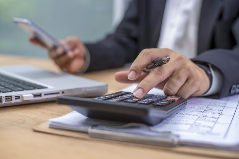 Cropped hands of a businessman calculating financial numbers
