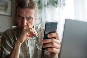 Older adult looking at a smart phone.