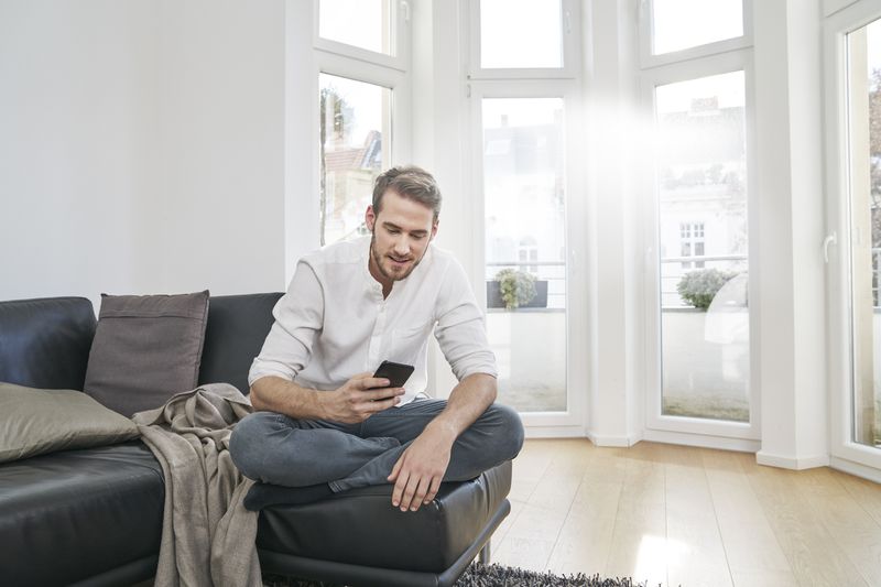 A man in a home uses a phone.