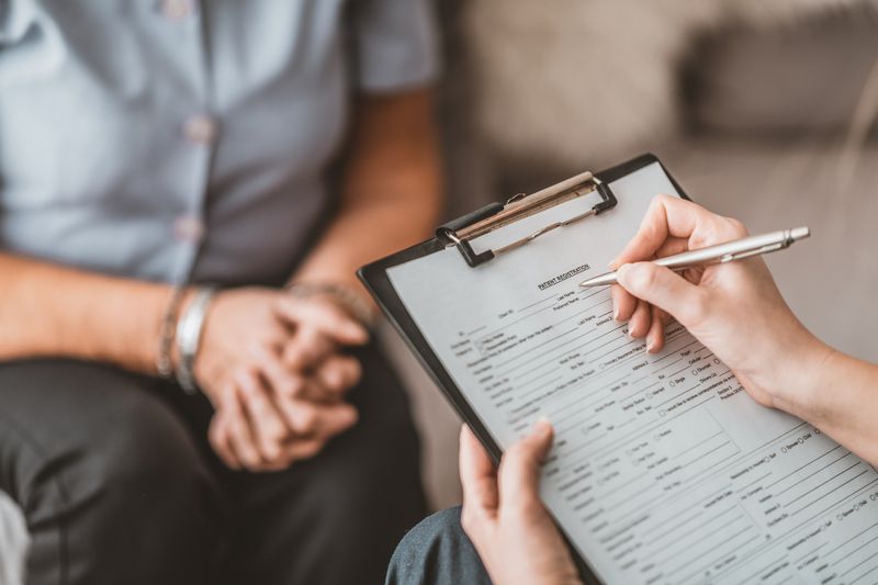 Person writing medical report on patient in care home