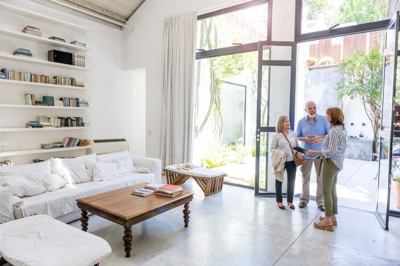 An older couple is viewing a house shown by the listing agent/realtor that will be commissioned under extender clause.