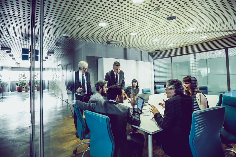 A group of business people having a meeting in an office and discussing a merger