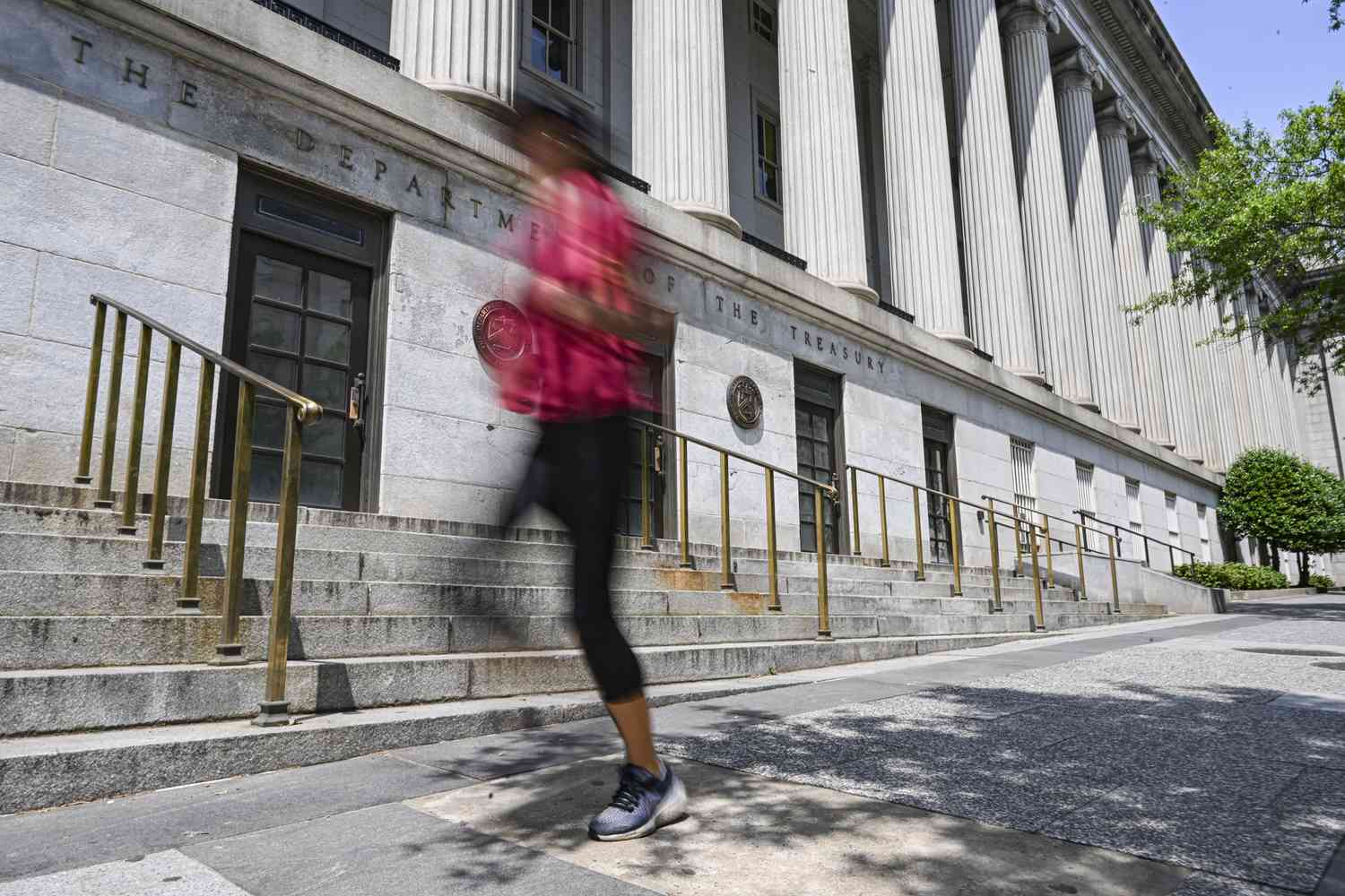 Person walking up the steps of the US Treasury building