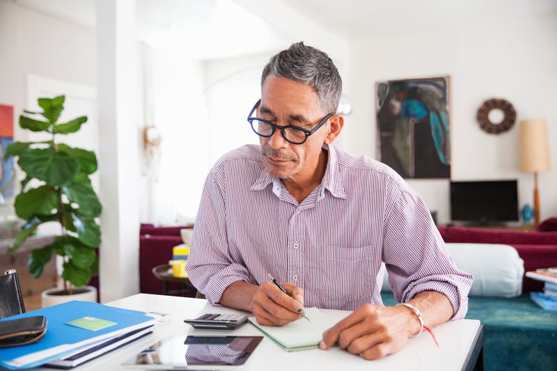 Man working on personal finance with calculator