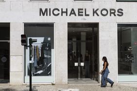 People walk by a Michael Kors store in Lisbon, Portugal.